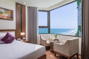 a hotel room with a bed and a large window at Rosamia Da Nang Hotel - My Khe Beachfront Luxury in Danang