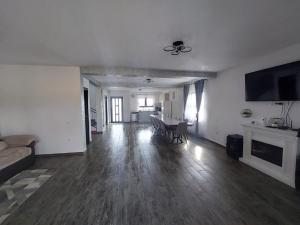an empty living room with a couch and a table at Vila Narci Paltinis in Păltiniş