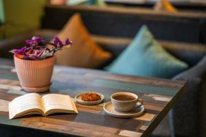an open book and a cup of coffee on a table at PACK Dharamkot in McLeod Ganj
