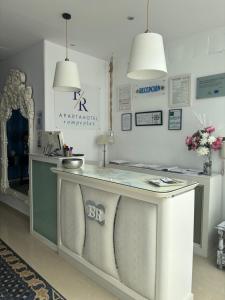 a kitchen with a counter with two pendant lights at Apartahotel Rompeolas in Conil de la Frontera