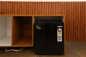 a black refrigerator sitting inside of a cabinet at Emmanuel Residency in Edappally +26 photos