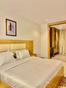 a bedroom with a large white bed in a room at Residence 541 Apartments and Suites in Abuja +72 photos