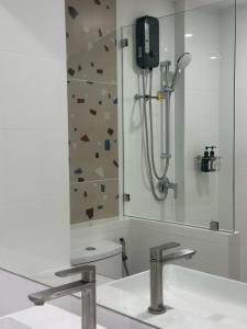a bathroom with a shower and a sink and a mirror at Pinotel Prachuap - โรงแรมพิโนเทล ประจวบ in Prachuap Khiri Khan +22 photos