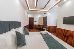a bedroom with a large bed with a flat screen tv at Emmanuel Residency in Edappally