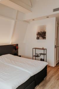 a bedroom with a large white bed in a room at Hotel Tholen in Tholen