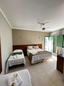 a bedroom with two beds and a ceiling at Pousada Solar dos Guarás in Catas Altas