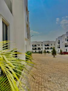 a courtyard of a building with palm trees in front of it at Residence 541 Apartments and Suites in Abuja