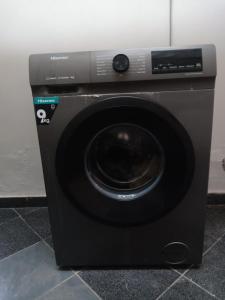 a black washing machine sitting on a tile floor at SarafuDeluxe in Nakuru +6 photos