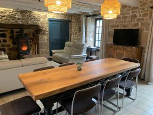 a living room with a large wooden table and chairs at Vacances au Lac de Saint-Pardoux in Compreignac