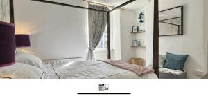 a bedroom with a mirror and a bed and a window at Snowdrop Cottage in Totnes