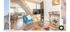 a living room with a blue chair and a fireplace at Snowdrop Cottage in Totnes