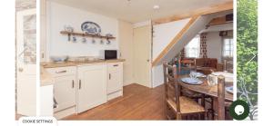 a kitchen with a table and a dining room at Snowdrop Cottage in Totnes