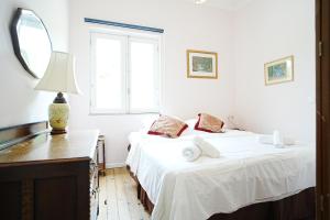 two beds in a white room with a mirror at casa do campinho in Fundoais +51 photos