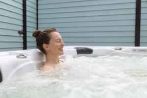 a woman laughing in a jacuzzi tub at Beach Motel St. Peter-Ording in Böhl