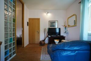 a living room with a blue couch and a television at casa do campinho in Fundoais