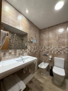 a bathroom with a sink and a toilet at Hotel Bahia in Gijón