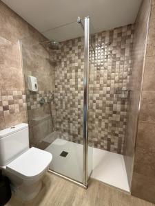 a bathroom with a toilet and a shower at Hotel Bahia in Gijón