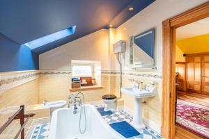 a bathroom with a tub and a sink and a toilet at The Doune, Luxury Traditional Country House with hot tub in Inverness +50 photos