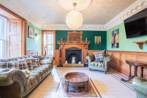a living room with a couch and a fireplace at The Doune, Luxury Traditional Country House with hot tub in Inverness