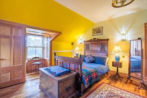 a bedroom with yellow walls and a bed and a window at The Doune, Luxury Traditional Country House with hot tub in Inverness