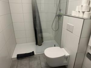 a white bathroom with a toilet and a shower at Gästehaus Ludwig in Rust