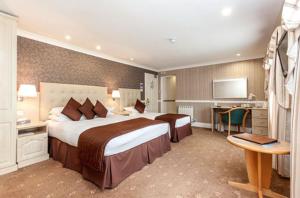a hotel room with a large bed and a desk at La Villette Hotel in St. Martin Guernsey +7 photos