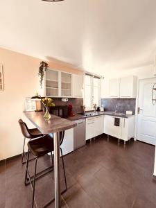 a kitchen with white cabinets and a table and chairs at La Madrague, Studio vue mer, Centre historique in Sainte-Maxime