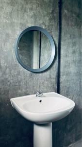 a bathroom sink with a mirror on the wall at Hideout Homestay in Ban Rai Pa Yoe +25 photos