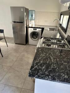 a kitchen with a stove and a washing machine at Departamento y aire libre in General Pico