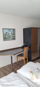 a room with a desk and a chair and a bed at Gasthof Moosmatt in Egolzwil
