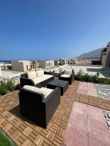 a patio with couches and tables on a roof at Hakuna Matata Villa - BF 515A in Muscat