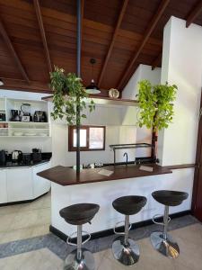 a kitchen with a counter with three stools at Casa Vibra Luz Guest House Familiar in Campeche