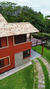 a red house with a deck on the side of it at Casa Vibra Luz Guest House Familiar in Campeche