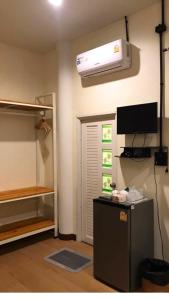 a room with a refrigerator and a air conditioner on the wall at Hideout Homestay in Ban Rai Pa Yoe