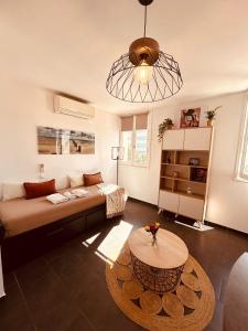 a living room with a couch and a table at La Madrague, Studio vue mer, Centre historique in Sainte-Maxime