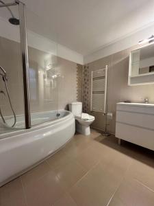 a bathroom with a tub and a toilet and a sink at Casa Liniștea Pădurii in Gura Văii +14 photos