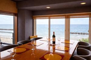 a dining room with a table and a view of the ocean at Moonbay Beach Villa in Lake Toya +57 photos