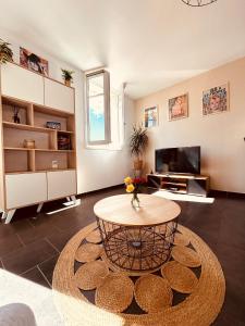 a living room with a table and a tv at La Madrague, Studio vue mer, Centre historique in Sainte-Maxime