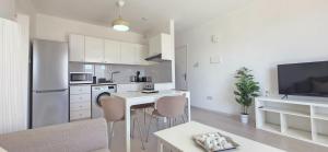 a kitchen with white cabinets and a table and chairs at White Aura by Staycom in Paphos