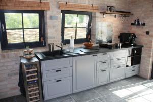 a kitchen with white cabinets and a black sink at Ferienhaus Sweet-Escape in Löningen