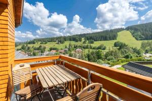 a wooden table and chairs on a balcony with a view at Hotel Schlehdorn in Feldberg