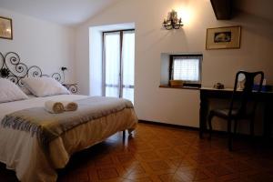a bedroom with a bed with a desk and a chair at La casa dei Percy in Varenna