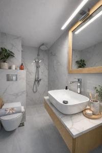 a bathroom with a white sink and a toilet at Opal Apartments Luxury by the Sea in Hersonissos