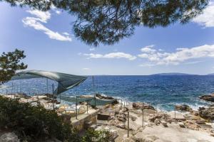 a beach with chairs and an umbrella and the ocean at Robinson Danica 1 in Gornji Dingač