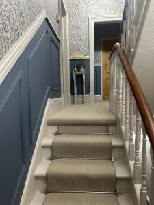 a stairway with blue and white walls and carpet at The Welford in Harrogate