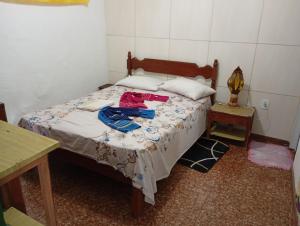 a bedroom with a bed with clothes on it at Casa na cidade ITAPARICA Bahia House in ITAPARICA town in Itaparica