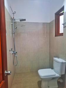 a bathroom with a toilet and a shower at Banana Leaf Villa in Nikawatawana