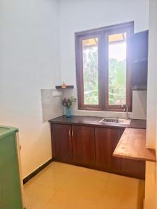 a kitchen with a sink and a window at Banana Leaf Villa in Nikawatawana