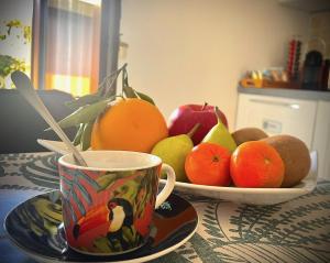 ein Tisch mit einem Teller Obst und einer Kaffeetasse in der Unterkunft Milele B&B in Somma Lombardo