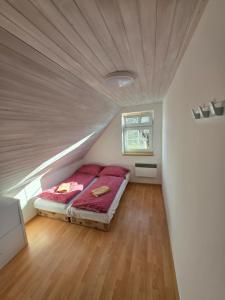 a bedroom with a bed with a wooden ceiling at Apartmány Kutěj in Mutěnice